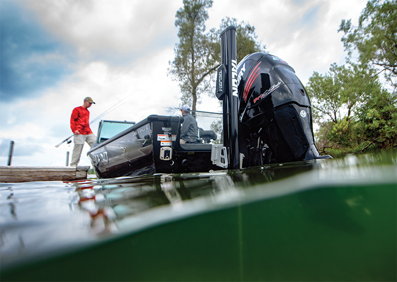 Eine Person steht auf einem Bootssteg neben einem Motorboot im Wasser, Motor und Ausrüstung sichtbar.